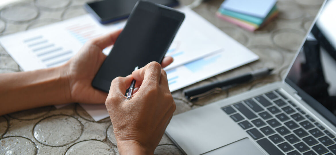 Hand of a business woman is using a mobile phone to find informa